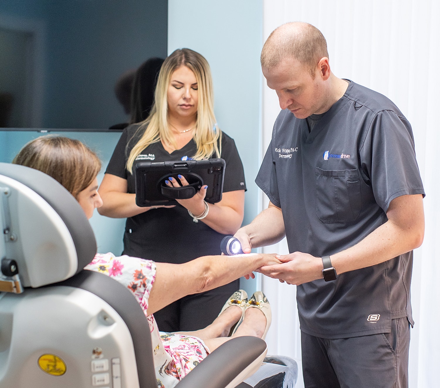 Medical professionals examining a patient's arm.
