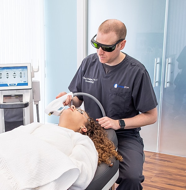 Dermatologist performing laser treatment on a patient.