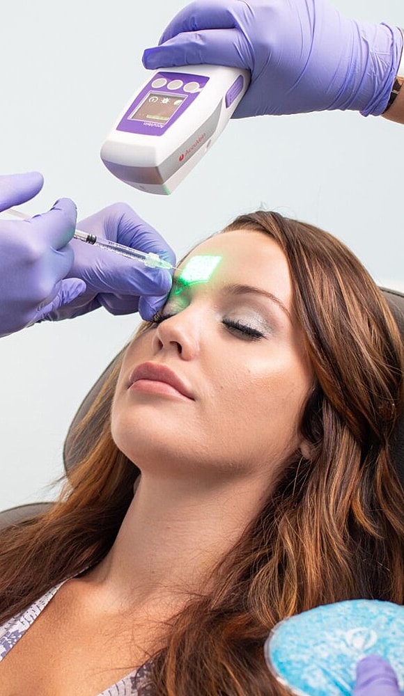 Woman receiving a skincare treatment with a laser.