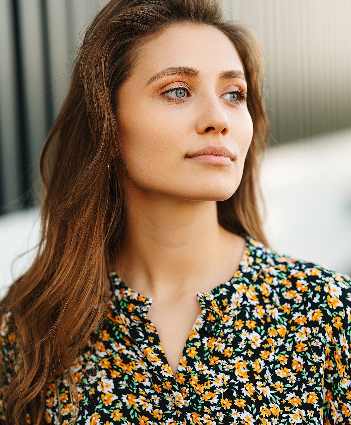 Young woman with long hair in floral shirt.