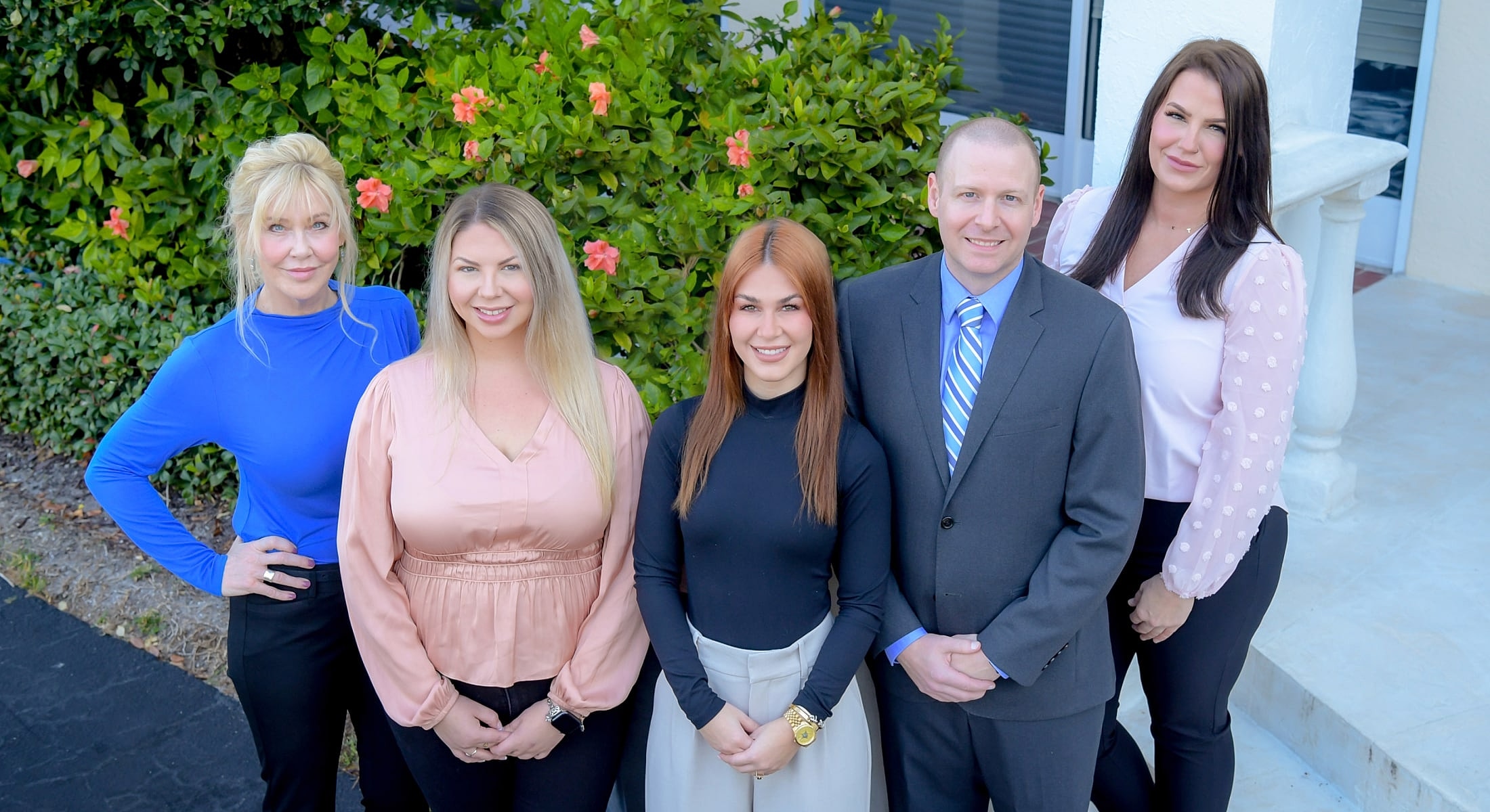 Group of professionals posing outdoors.