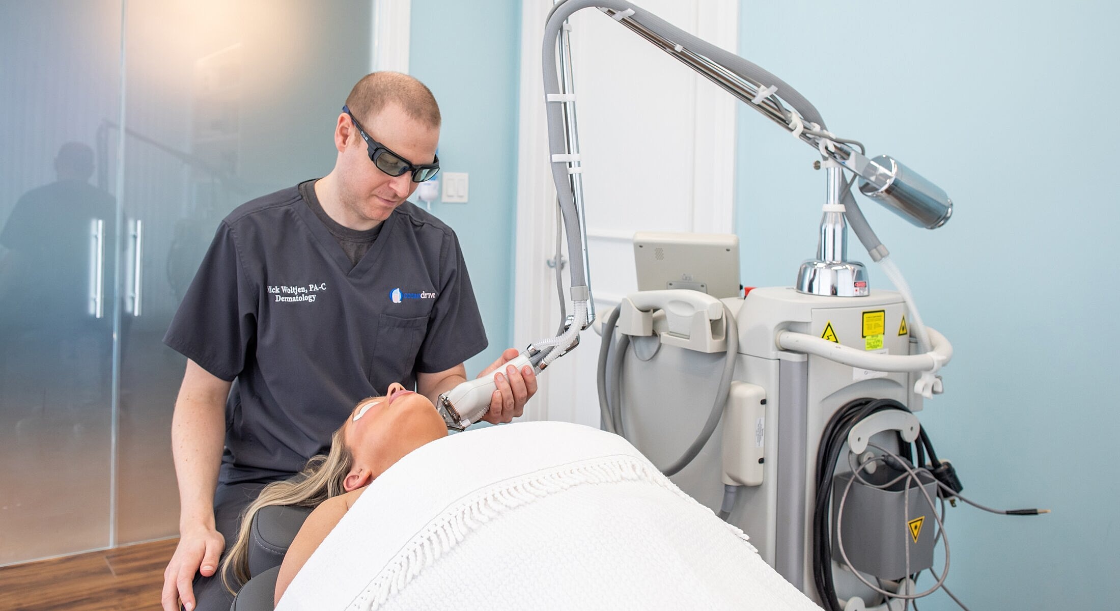 Dermatologist performing laser treatment on patient.