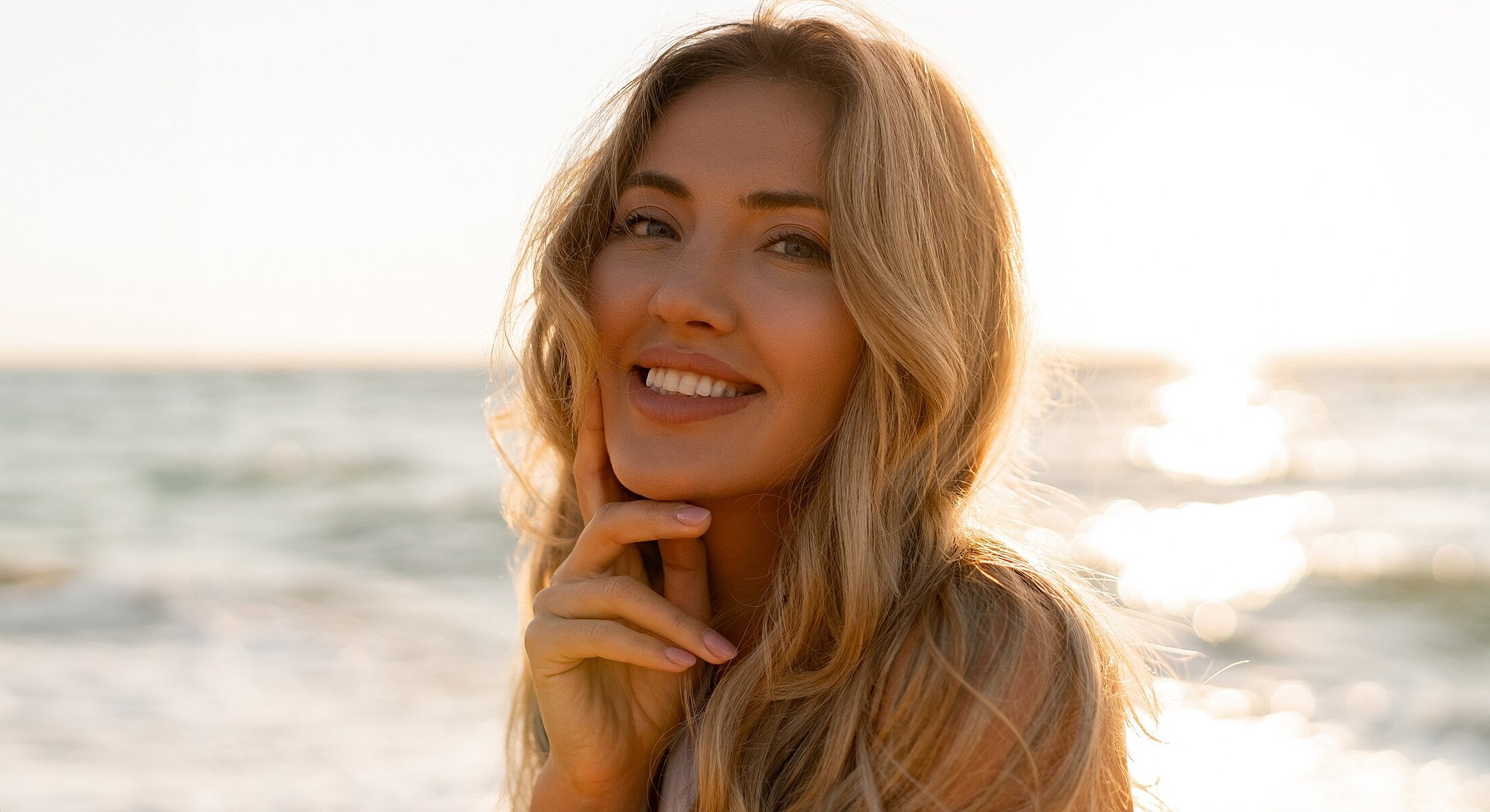 Smiling woman by the beach during sunset.