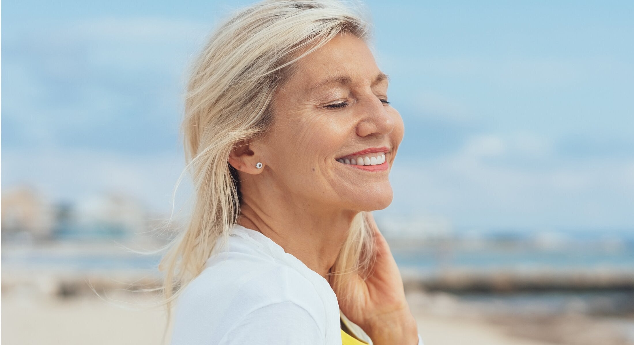 Smiling woman enjoying a sunny beach day.