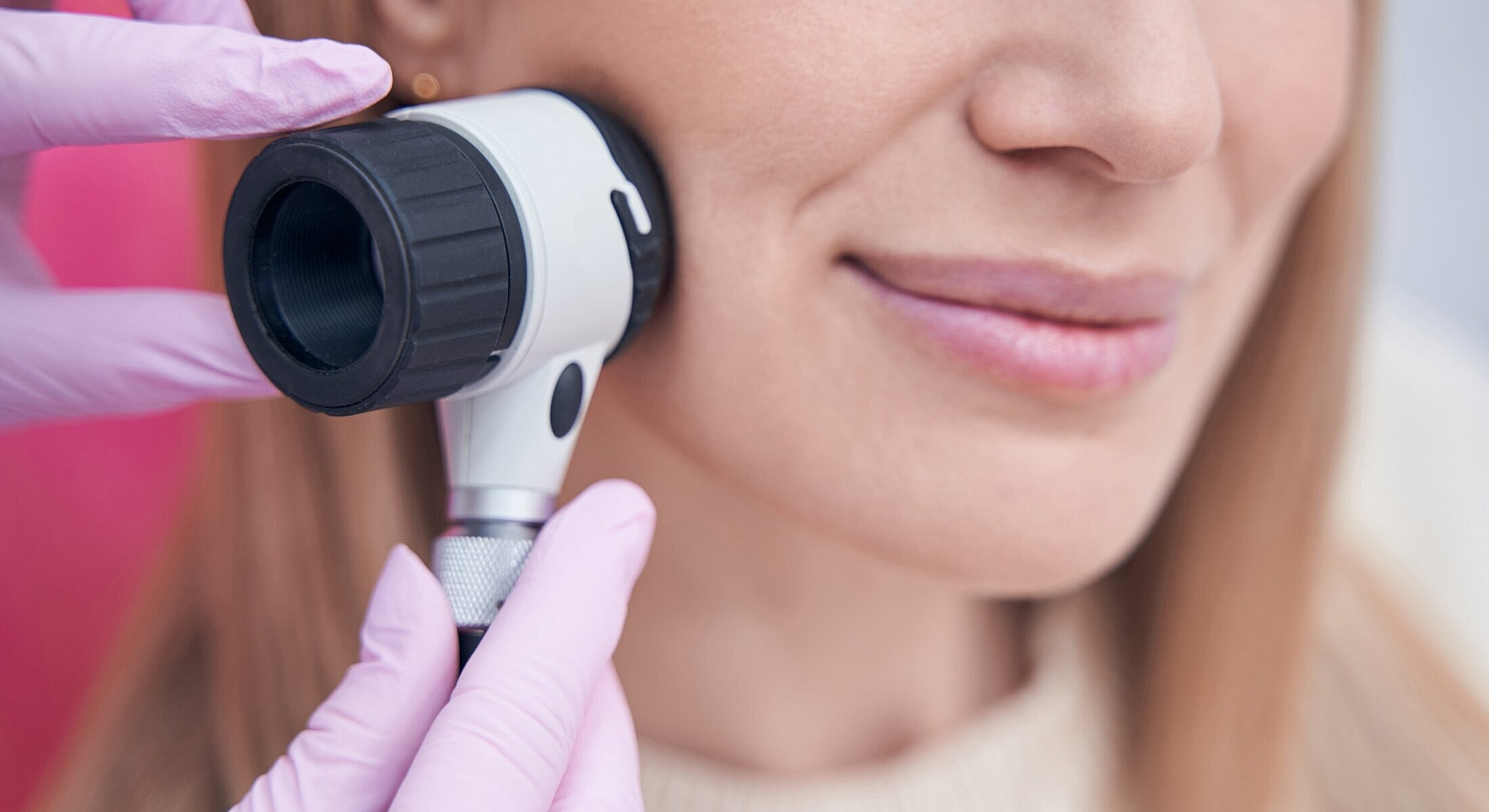 Dermatologist examining skin with a dermatoscope.